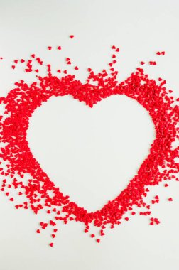 Sevgililer Günü aşk geçmişi. Büyük bir kalp şeklinde kırmızı kalp şekeri. Sevgililer Günü için krem kartı. Uzayı kopyala, üst görünüm. Dikey yönelim.