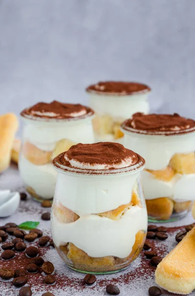 Gourmet Italian tiramisu dessert in a glass sprinkled with cocoa and decorated frozen berries. Vertical orientation. Copy space — Stock Photo, Image