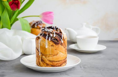 Paskalya geçmişi. Paskalya pastası - Cruffin, Kraffin veya Kulich çikolatalı fındık kreması ve şeker jöleli beton arka planda beyaz bir tabakta. Yatay oryantasyon. Boşluğu kopyala