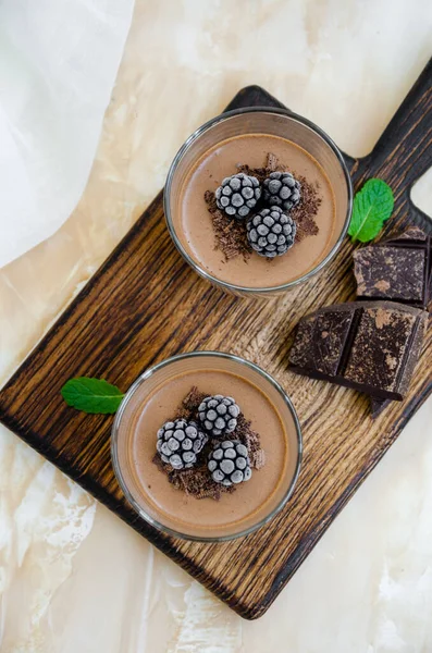 意大利甜品 巧克力煎饼 奶油或布丁与黑莓在玻璃杯中的轻混凝土背景板 垂直方向 顶部视图 — 图库照片