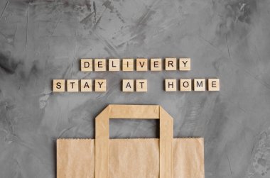 Ürünlerin teslimatı, evde yiyecekler. Koyu beton arka planda kağıt torba. Evde kal. Yatay, üst görünüm, boşluğu kopyala