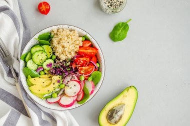 Taze sebzeli kinoa salatası, ıspanak, yeşil bezelye, mikroyeşil ve susam tohumları beton arka planda bir kasede. Sağlıklı gıda konsepti. Yatay oryantasyon. Üst görünüm, alanı kopyala