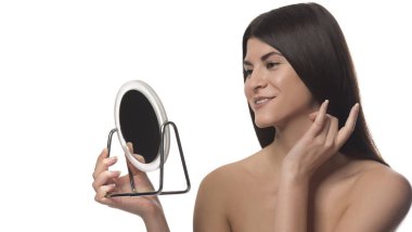 Bir ayna ile siting genç esmer kız. Güzellik kavramı. Beyaz arka plan üzerinde izole