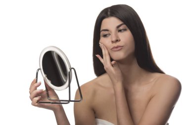 Bir ayna ile siting genç esmer kız. Güzellik kavramı. Beyaz arka plan üzerinde izole