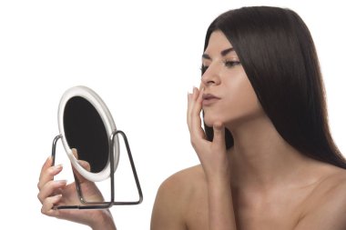 Bir ayna ile siting genç esmer kız. Güzellik kavramı. Beyaz arka plan üzerinde izole