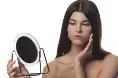 Bir ayna ile siting genç esmer kız. Güzellik kavramı. Beyaz arka plan üzerinde izole