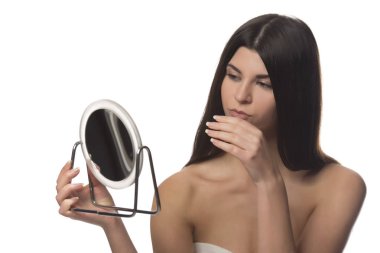 Bir ayna ile siting genç esmer kız. Güzellik kavramı. Beyaz arka plan üzerinde izole