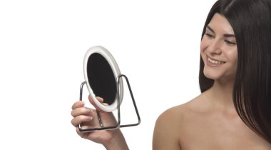 Bir ayna ile siting genç esmer kız. Güzellik kavramı. Beyaz arka plan üzerinde izole