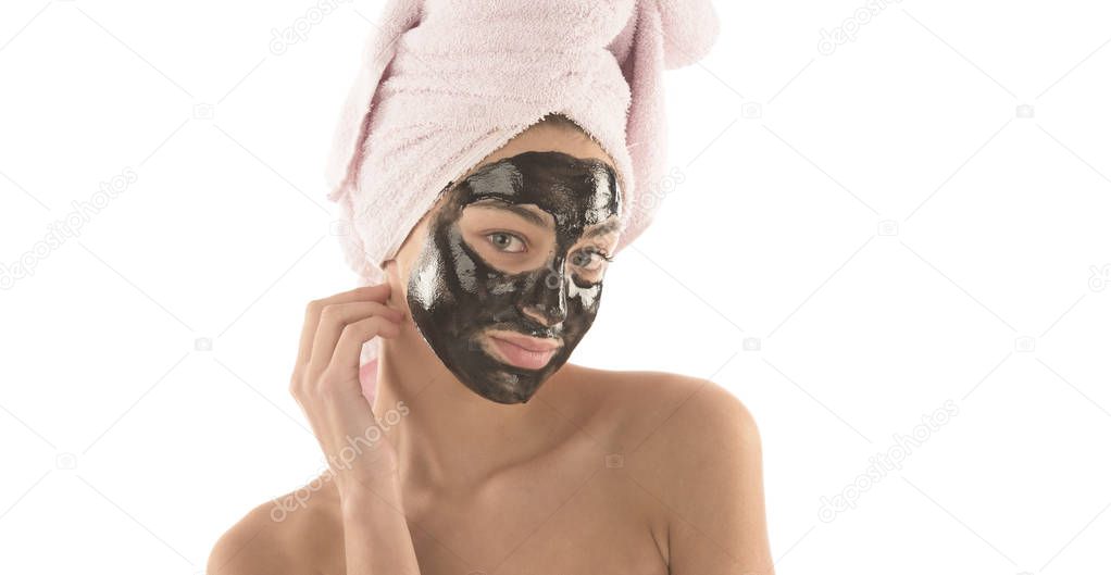 Beautiful girl with black facial cosmetic mask. Beauty concept. Isolated on white background