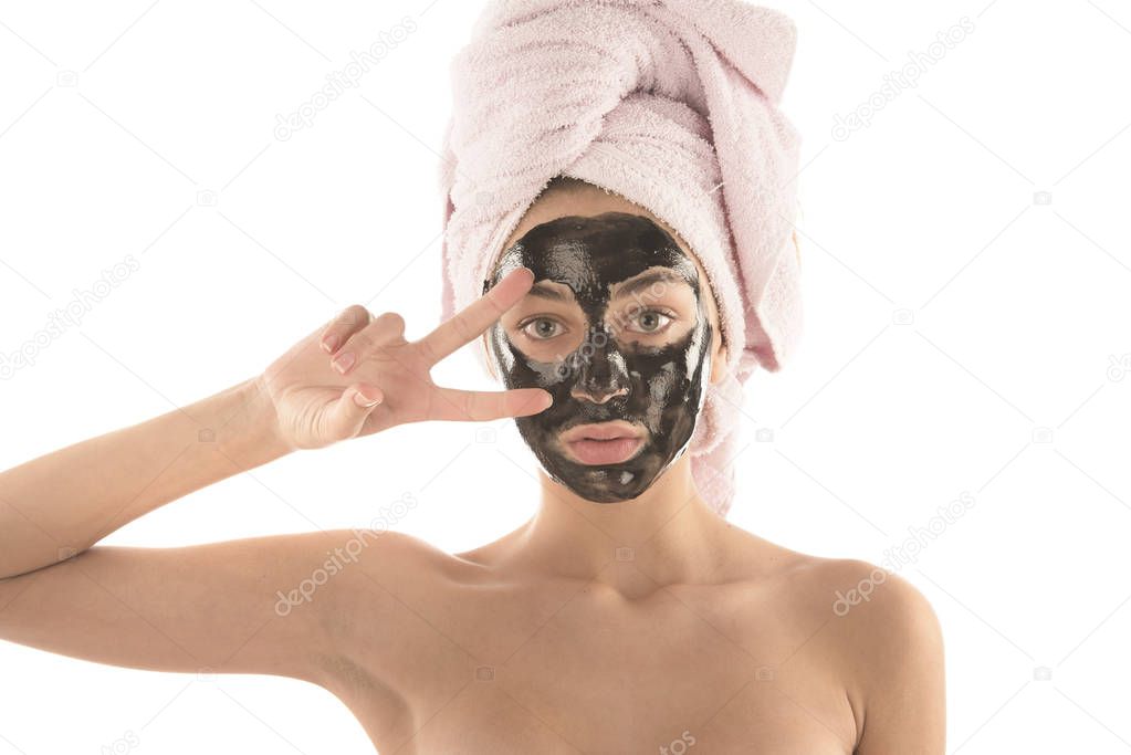 Beautiful girl with black facial cosmetic mask. Beauty concept. Isolated on white background