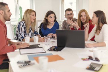 Bir müşteriyle konferans salonuna sahip iş arkadaşları. Grup onay için istemciye tasarımlar gösterilen süre sohbet ediyor insan. İş kavramı.