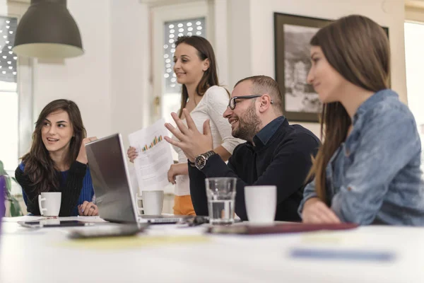 Colleagues having a meeting with client in conference room. Group of people having a conversation while showing designs to client for approval. Business concept.