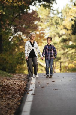 Büyükanne ve torunu ormanda yol boyunca yürüyüş