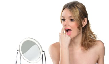 burnunu ayna önünde dokunmadan güzel ve genç birbayan. Beyaz arka plan üzerinde izole