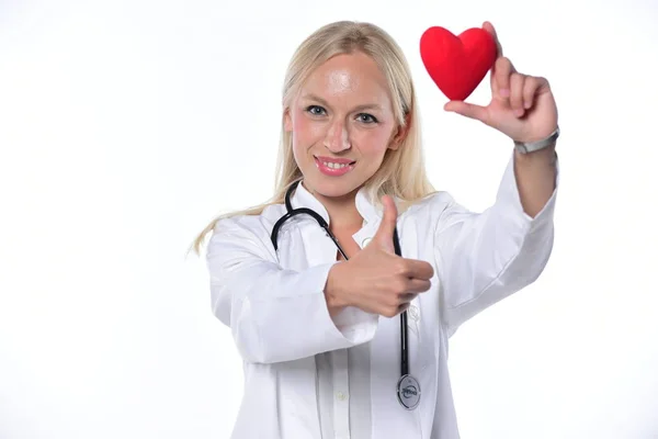 Χαμογελαστή Γυναίκα Γιατρό Κρατώντας Κόκκινη Καρδιά Και Δείχνει Τους Αντίχειρες — Φωτογραφία Αρχείου