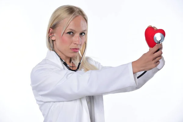 年轻女性医生用红色心脏和听诊器 在白色背景上被隔离 — 图库照片