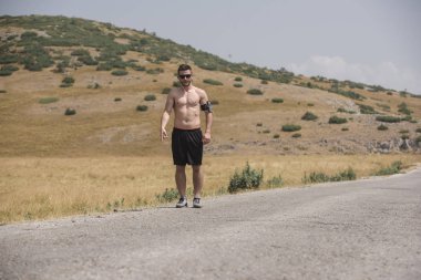 Erkek koşucu güneşin altında dağda koşuyor - sağlıklı yaşam tarzı kavramı