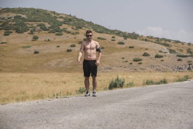 Erkek koşucu güneşin altında dağda koşuyor - sağlıklı yaşam tarzı kavramı