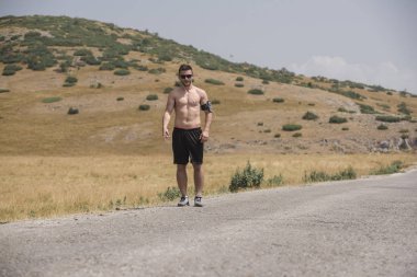 Erkek koşucu güneşin altında dağda koşuyor - sağlıklı yaşam tarzı kavramı