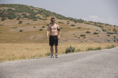 Erkek koşucu güneşin altında dağda koşuyor - sağlıklı yaşam tarzı kavramı