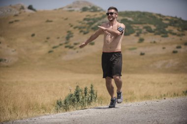 Erkek koşucu güneşin altında dağda koşuyor - sağlıklı yaşam tarzı kavramı