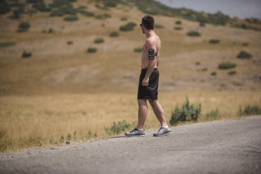 Erkek koşucu güneşin altında dağda koşuyor - sağlıklı yaşam tarzı kavramı