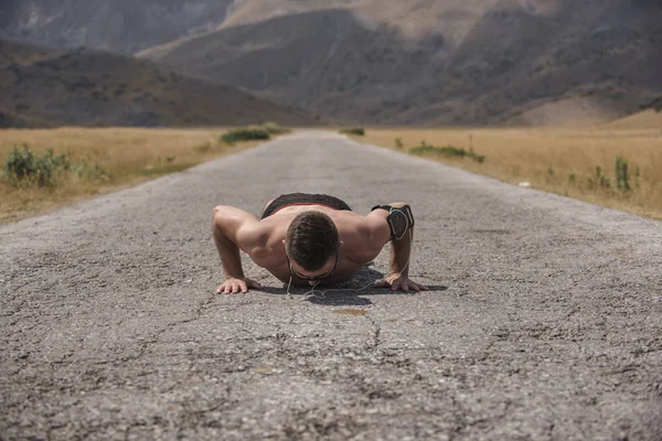 Corredor Masculino Haciendo Flexiones Carretera Montaña Bajo Sol Con Enfoque — Foto de Stock