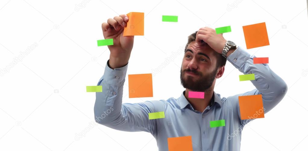 Businessman thinking over white studio background and using sticky notes
