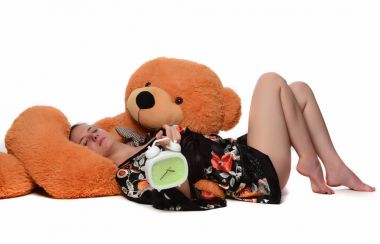 Büyük Peluş ayı ve çalar saat beyaz arka plan üzerinde izole olan kadın