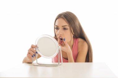 Genç ve güzel kadın olun bir balık yüz beyaz zemin üzerinde bir ayna önünde