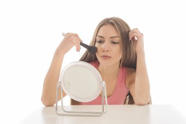 Makyaj uygulanması, bir fırça ve ayna kullanarak genç güzel kadın