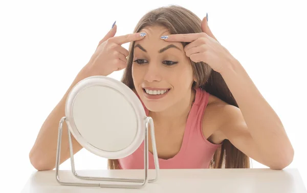 美丽的年轻女子在镜子前举起眉毛 — 图库照片