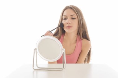 Makyaj uygulanması, bir fırça ve ayna kullanarak genç güzel kadın