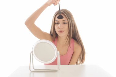 Makyaj uygulanması, bir fırça ve ayna kullanarak genç güzel kadın