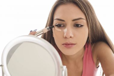  genç kadın bir kapatıcı gözlerinin altında geçerlidir. Beyaz arka plan üzerinde izole