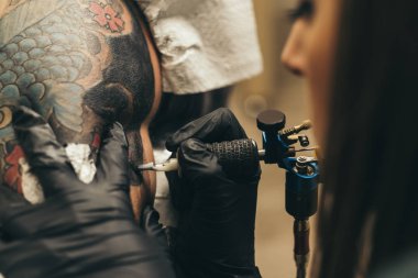 Profesyonel ustası olan bir dövme sanatçısı bir stüdyoda çalışıyor.