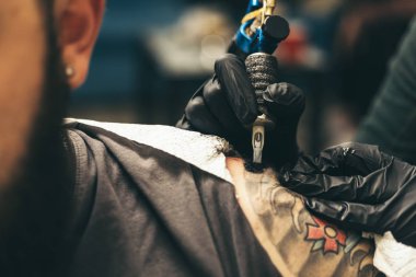 Dövme sanatçısı bir atölyede profesyonel bir ustayla çalışıyor..