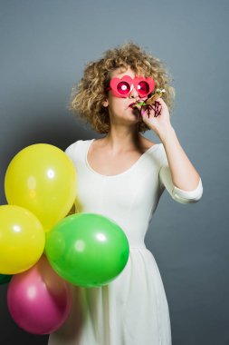 Balonlar tutan mutlu komik sarışın kadın