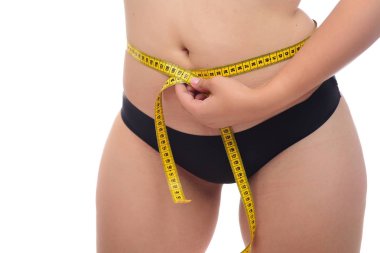 Beyaz arka plan üzerinde izole bant ölçme ile kilolu kadın