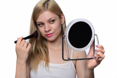 Makyaj uygulanması, bir fırça ve ayna kullanarak sarışın genç kadın