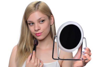 Makyaj uygulanması, bir fırça ve ayna kullanarak sarışın genç kadın