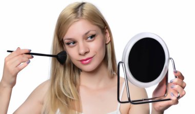Makyaj uygulanması, bir fırça ve ayna kullanarak sarışın genç kadın