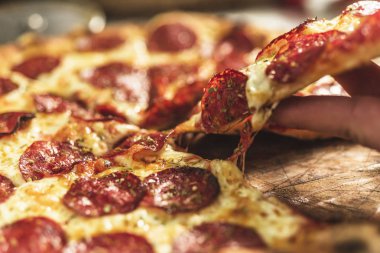 Peynir ve rustik ahşap bir masa üzerinde erime ile sıcak pizza