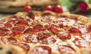 Peynir ve rustik ahşap bir masa üzerinde erime ile sıcak pizza