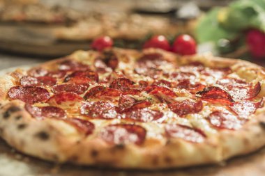 Peynir ve rustik ahşap bir masa üzerinde erime ile sıcak pizza