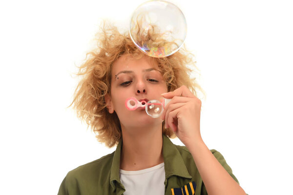 Attractive blonde woman making soap bubbles. isolated on white background