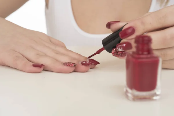 Manicure process at home. Woman painting her nails on white background