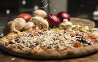 Eritilmiş peynir, İtalyan otlar ve domates sos ve taze fesleğen taze pişmiş pizza. Seçici odak