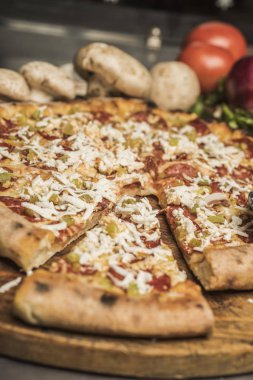 Eritilmiş peynir, İtalyan otlar ve domates sos ve taze fesleğen taze pişmiş pizza. Seçici odak