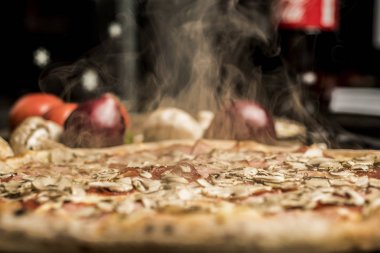 Eritilmiş peynir, İtalyan otlar ve domates sos ve taze fesleğen taze pişmiş pizza. Seçici odak